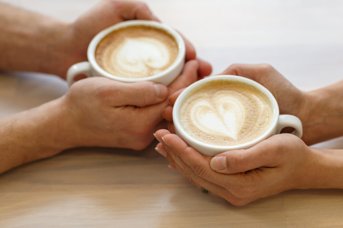 Couple drinking coffee in a cafe man and woman with a cup of hot latte Selective focus | コーヒーステーション