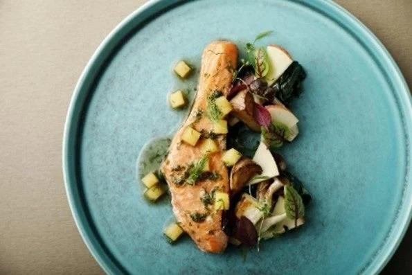 ターコイズブルーの皿に盛り付けられたサーモン料理