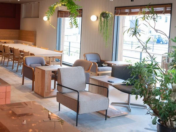 自然光が差し込む広々としたカフェまたはワークスペースの室内風景