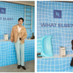 Advertisement panel with a sunset city backdrop and a woman beside a row of coffee machines slogan WHAT ELSE EVERY COFFEE A NEW WORLD