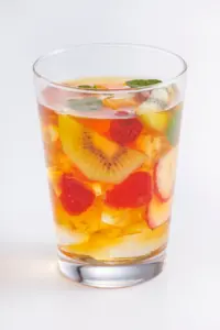 1a562a31b5c4373db2d1821e9532b6a7 | コーヒーステーション Glass of fruit infused drink with visible kiwi slices raspberries and mint leaves over ice in a clear glass