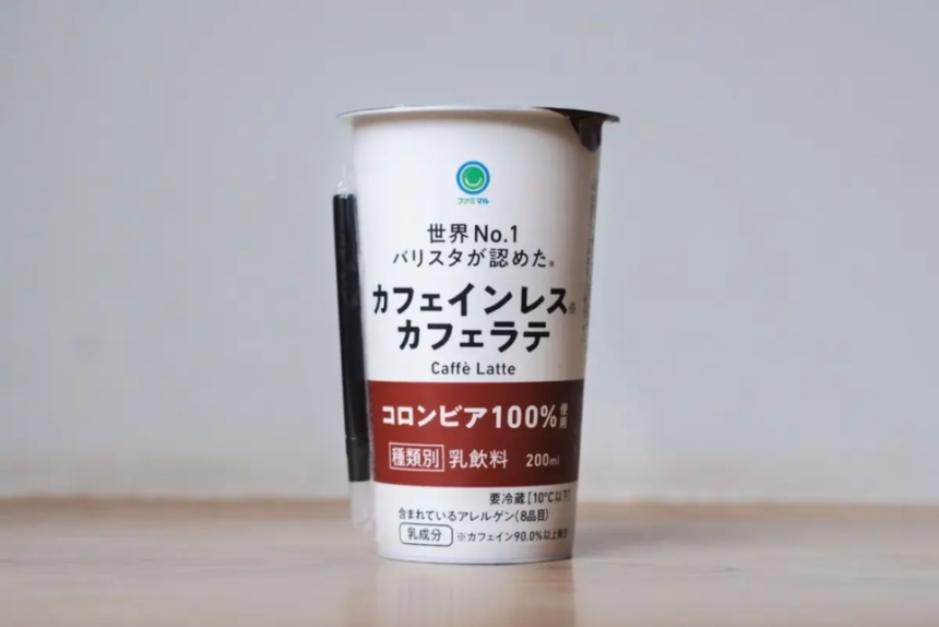 Canned caffe latte drink with Japanese text on a white and maroon label standing on a wooden table