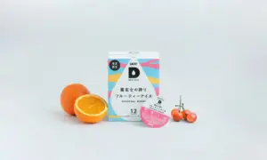 UCC Drip Pod Seasonal Blend box with an orange half and a small cluster of cherry tomatoes on a pale background