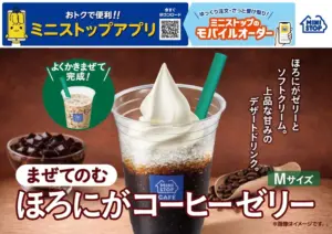 透明カップのコーヒーゼリーとソフトクリームのデザートドリンク緑のストロー付き木目背景の広告画像ミニストップのカフェデザート広告コーヒーゼリー入りの黒いドリンクとホイップ緑のストロー