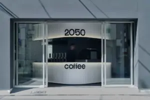 5420dbfae9eac5baf63dafb51f7040f9 | コーヒーステーション Glass storefront with a curved silver counter that reads coffee inside a modern cafe number 2050 above the counter