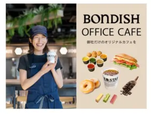 631e1b14d0fcddfebca112c948e734cb | コーヒーステーション Cheerful cafe worker in a navy apron holds a coffee cup beside a Bondish Office Cafe promo panel with drinks donut sandwich and Japanese text