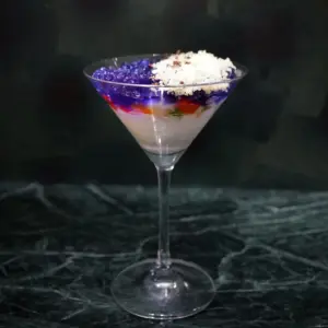 788eb6add76eabdb6db7b76c9de635fd | コーヒーステーション Martini glass dessert cocktail with white base purple jelly layer colorful fruit pieces and sprinkled coconut on top