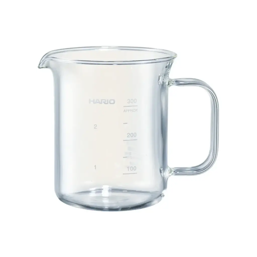 Clear glass measuring pitcher with a spout and handle displaying measurement marks up to 300 ml