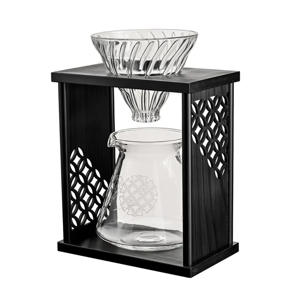 Pour over coffee maker glass dripper atop a dark wooden frame with a glass carafe below ready for brewing