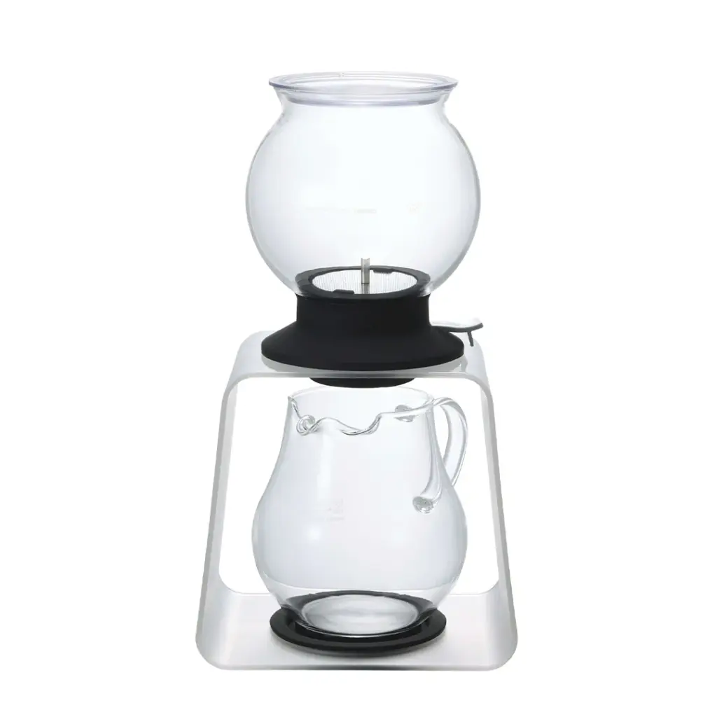 Siphon coffee maker with two glass chambers on a white stand ready for brewing coffee