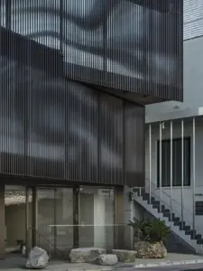 ad54effa1d8755fa6acd69756f496c9e | コーヒーステーション Modern building facade with vertical metal louvers glass entrance and an external staircase in view