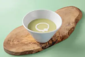 c568e342b6e79d46efa33fb6ef53f386 | コーヒーステーション White bowl of olive oil with a circular salt ring on a rustic wooden board against a pale green background