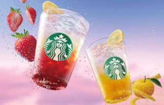 Two Starbucks iced drinks with strawberry and lemon fruit accents shown mid air with splashes against a pink blue sky