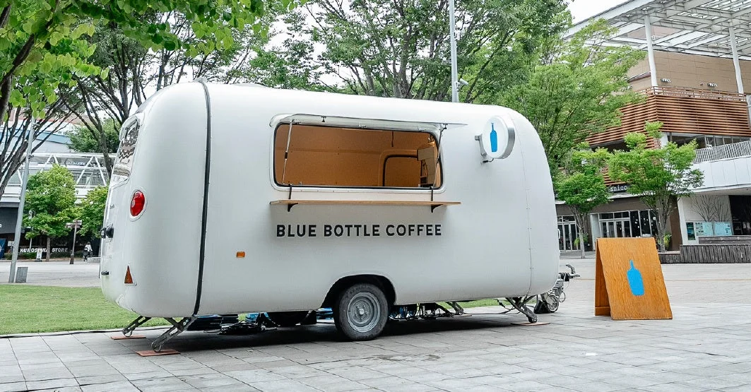 屋外の広場に設置されたブルーボトルコーヒーの移動販売車