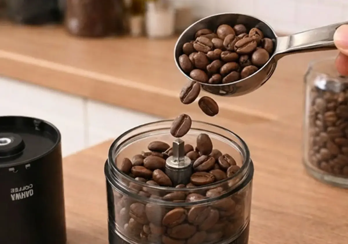 コーヒー豆を電動ミルに入れる様子