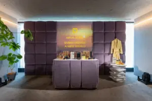 Purple velvet tufted backdrop and display table featuring coffee machines for a brand activation with a robe on the right and a potted plant on the left
