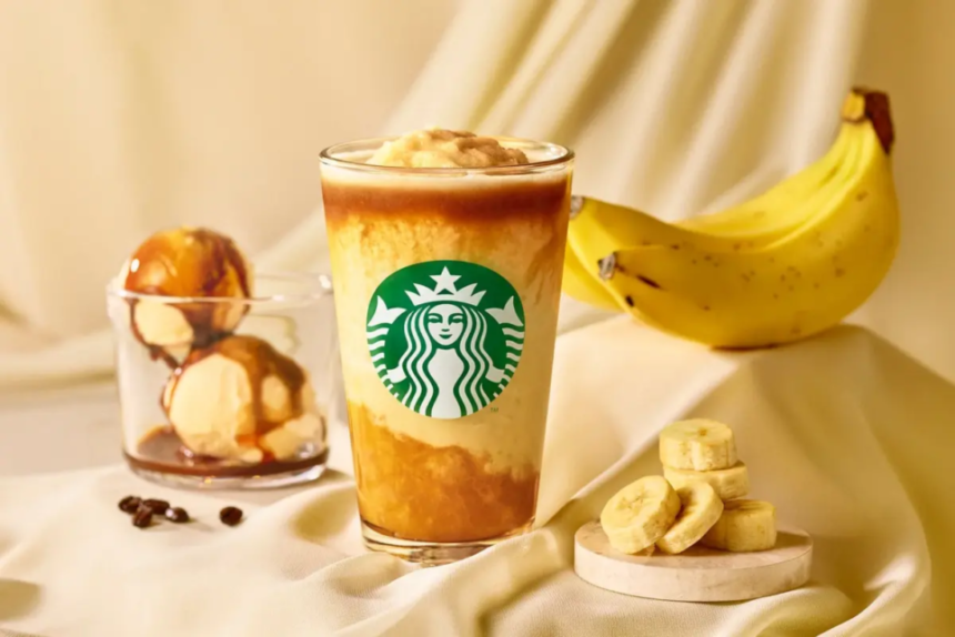 Starbucks iced beverage with layered yellow and brown tones logo visible set on a beige fabric with bananas and dessert items nearby
