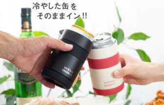 Two hands clink black and white WENS Products 2 way tumblers over a table with bread and salad
