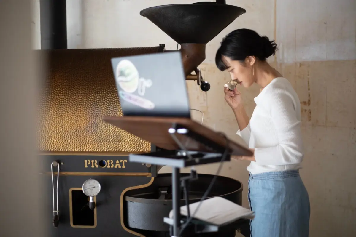 renag coffeeの品質管理（女性が焙煎機の前でテイスティング）