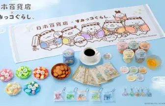 Assortment of colorful Japanese candies and snacks arranged on a light blue surface with a white towel featuring Sumikko Gurashi characters in the background