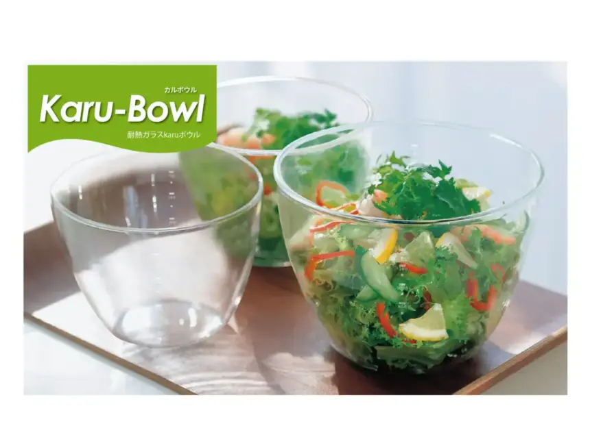 Glass bowls on a wooden tray with a fresh salad in the right bowl green Kar Bowl logo in the top left corner