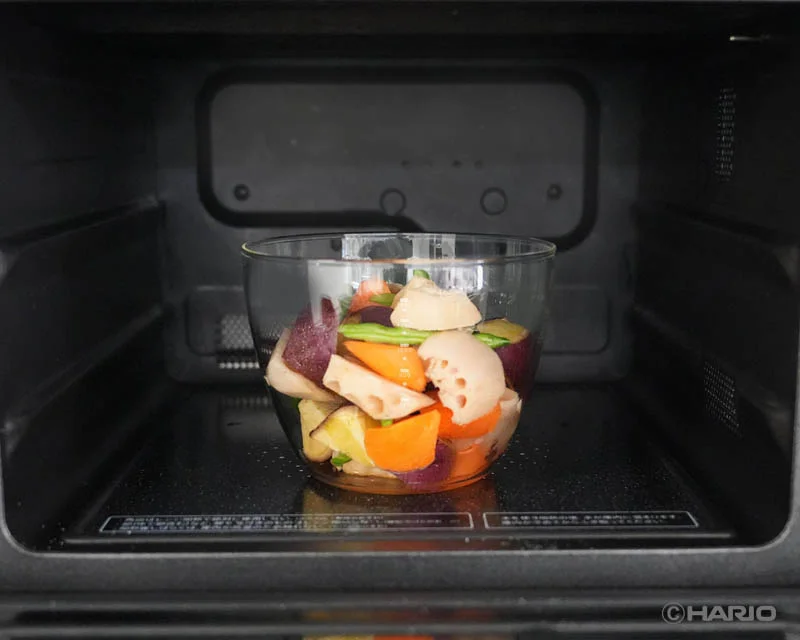 22751233009c01a30f79d048e4c565e8cdf7e4e800x640 | コーヒーステーション Glass bowl with chopped vegetables carrot lotus root purple potato green beans inside a microwave ready to cook