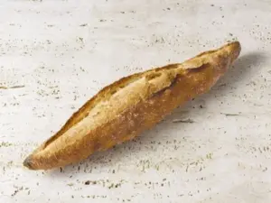 Crusty baguette loaf on a light textured surface