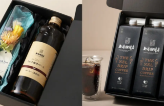 Gift box with a dark bottle labeled coffee and a wrapped bouquet with a Thank You tag inside a black box on the left and a row of The Nel Drip Coffee cartons with a glass of iced coffee on the right