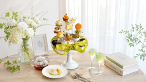 57b8b655404a0ee904c735c93860015aresized1000x562 | コーヒーステーション Elegant table setting with a white tiered pastry stand green ribbon floral vase and fluted glasses of green tea beside books and a plate with a bite sized treat