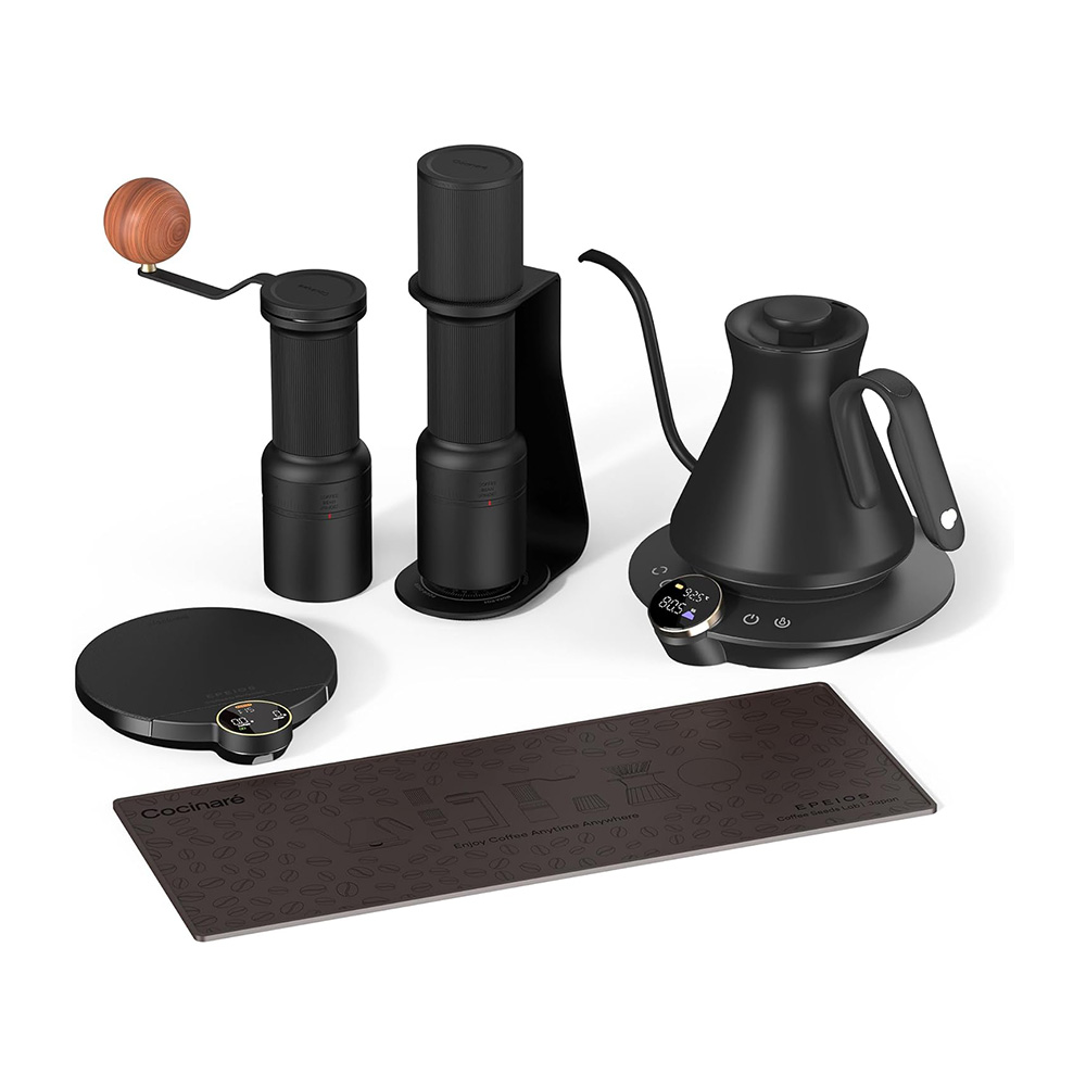 Set of black coffee brewing tools two grinders a gooseneck kettle a digital scale and a patterned mat on a white background