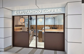 Sarutahiko Coffee storefront with glass doors and brown panels warm wooden interior visible inside