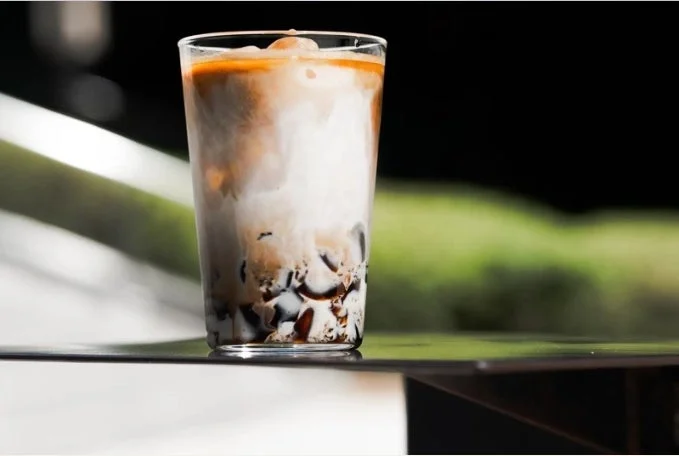 層になったアイスミルクコーヒーと黒いゼリー状の具材