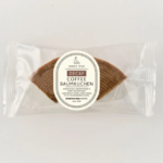 Single packaged decaf coffee Baumkuchen cookie in a clear plastic wrapper with a circular label reading Decaf Coffee Baumkuchen on top of the cookie