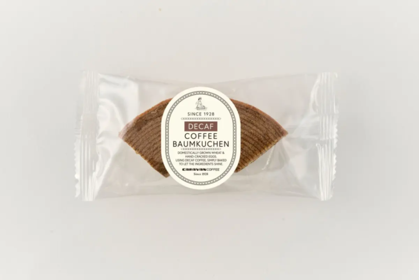 Single packaged decaf coffee Baumkuchen cookie in a clear plastic wrapper with a circular label reading Decaf Coffee Baumkuchen on top of the cookie