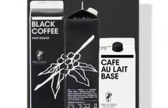 Tray containing three beverage cartons a black coffee non sugar carton on the left a tall black bottle in the center and a cafe au lait base carton on the right all feature the Philocoffea branding and white text