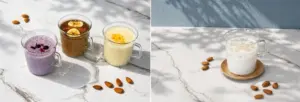 9a87f5effa917454893ce542865f53aa | コーヒーステーション Left three clear mugs with purple brown and yellow smoothies on a marble surface almonds scattered nearby right a glass of almond milk with almonds around