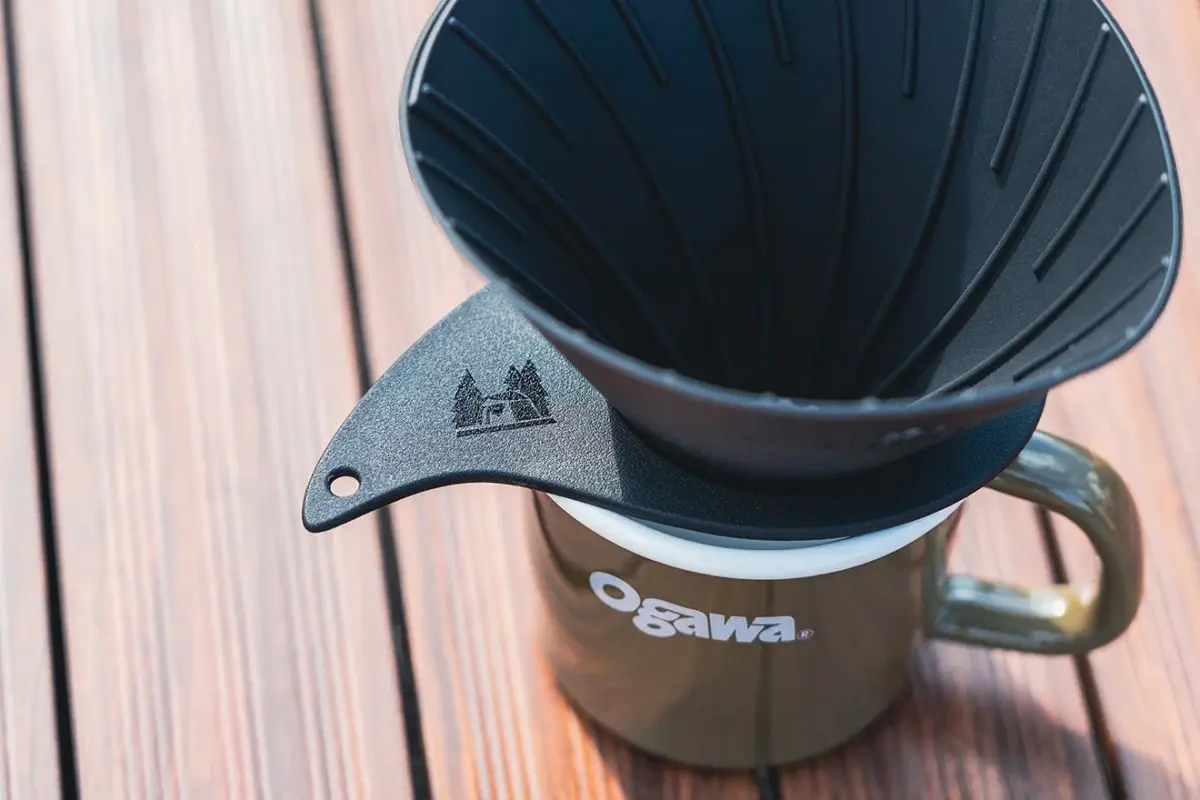 Pour over coffee dripper sitting on an Ogawa mug on a wooden table surface