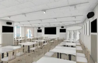 Bright modern dining hall or conference room with white tables and light wood chairs, wall-mounted screens, and track lighting.