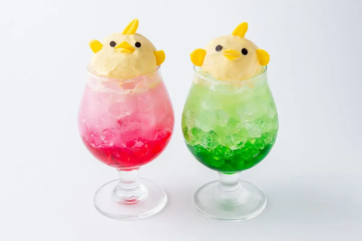ひよこの形のアイスクリームが乗った、ピンクとグリーンの可愛らしいクリームソーダが2つ並んでいます。見た目も鮮やかで、涼しげなデザートドリンクです。