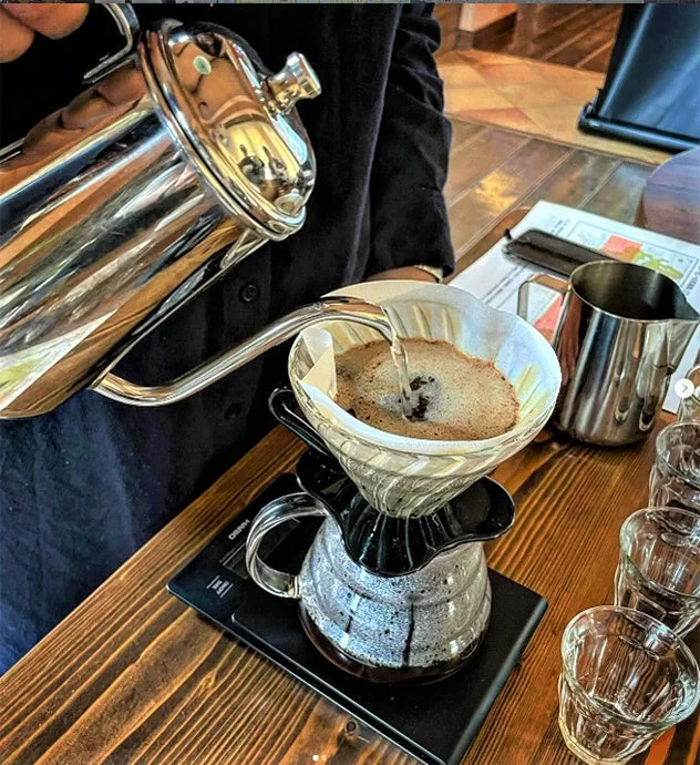 ドリップケトルからお湯を注ぎ丁寧にコーヒーを淹れる様子