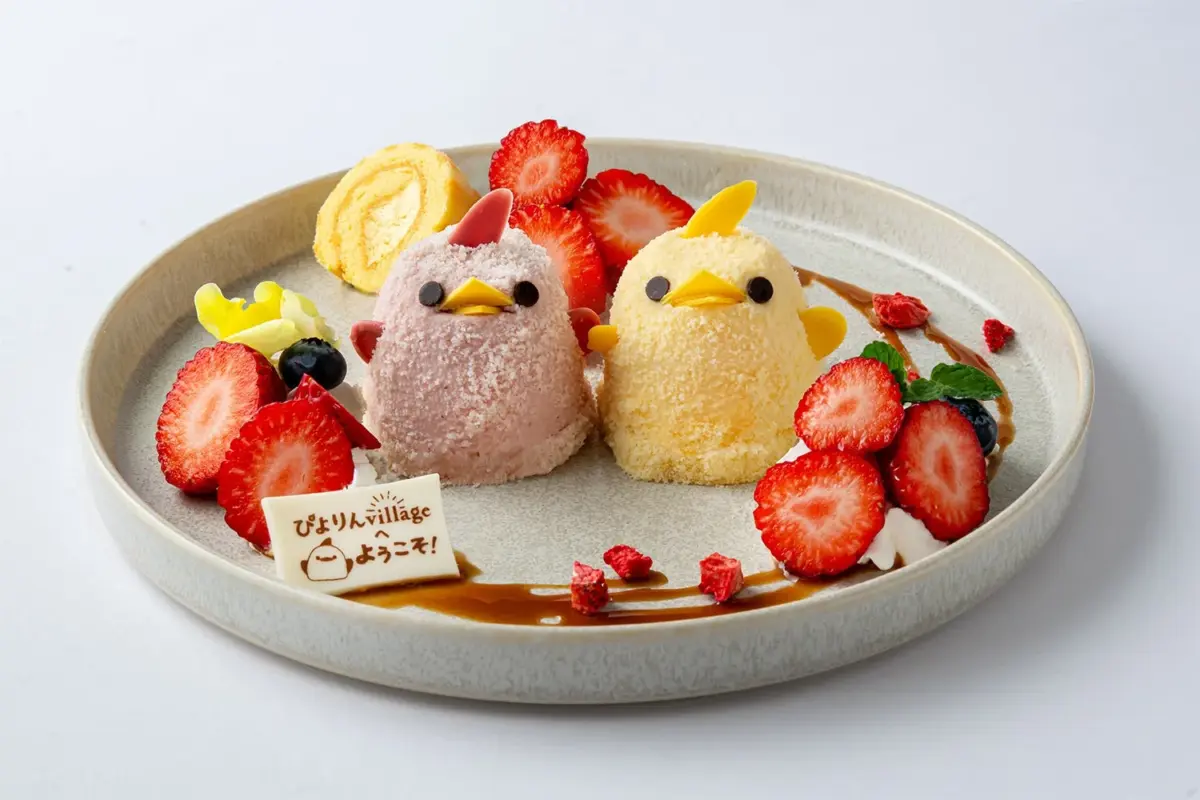 可愛らしいひよこ型のデザートが2つ、いちごやロールケーキと共に盛り付けられたプレート。ピンクと黄色のひよこが愛らしく、見る人を和ませるスイーツです。