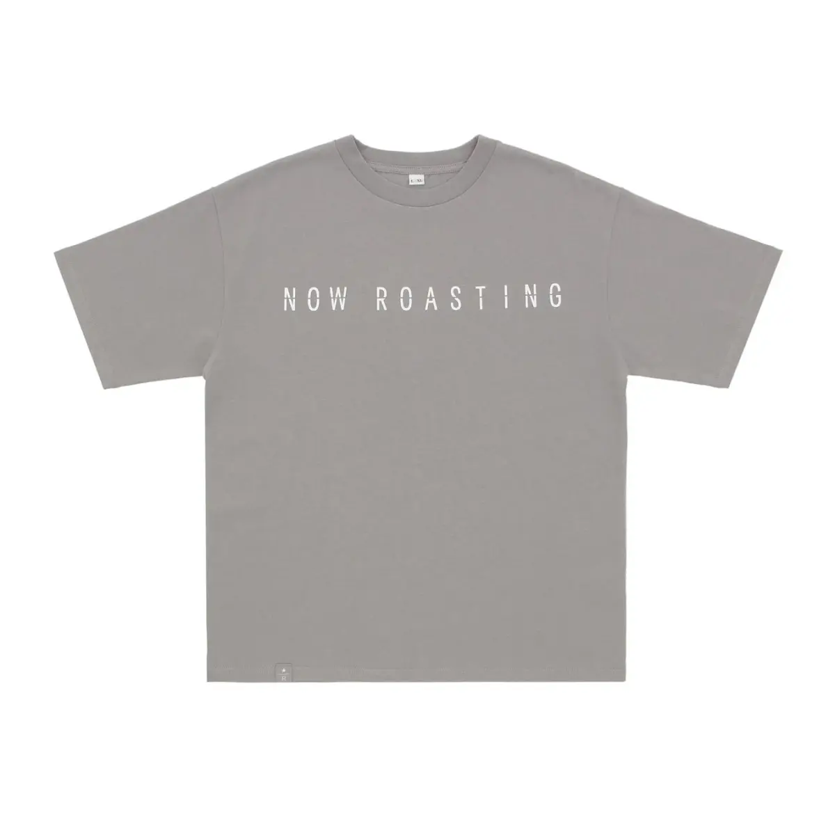 「NOW ROASTING」と白い文字でプリントされたグレーの半袖Tシャツです。首元にはL-XLのサイズ表記があり、シンプルなデザインでカジュアルなスタイルに適しています。