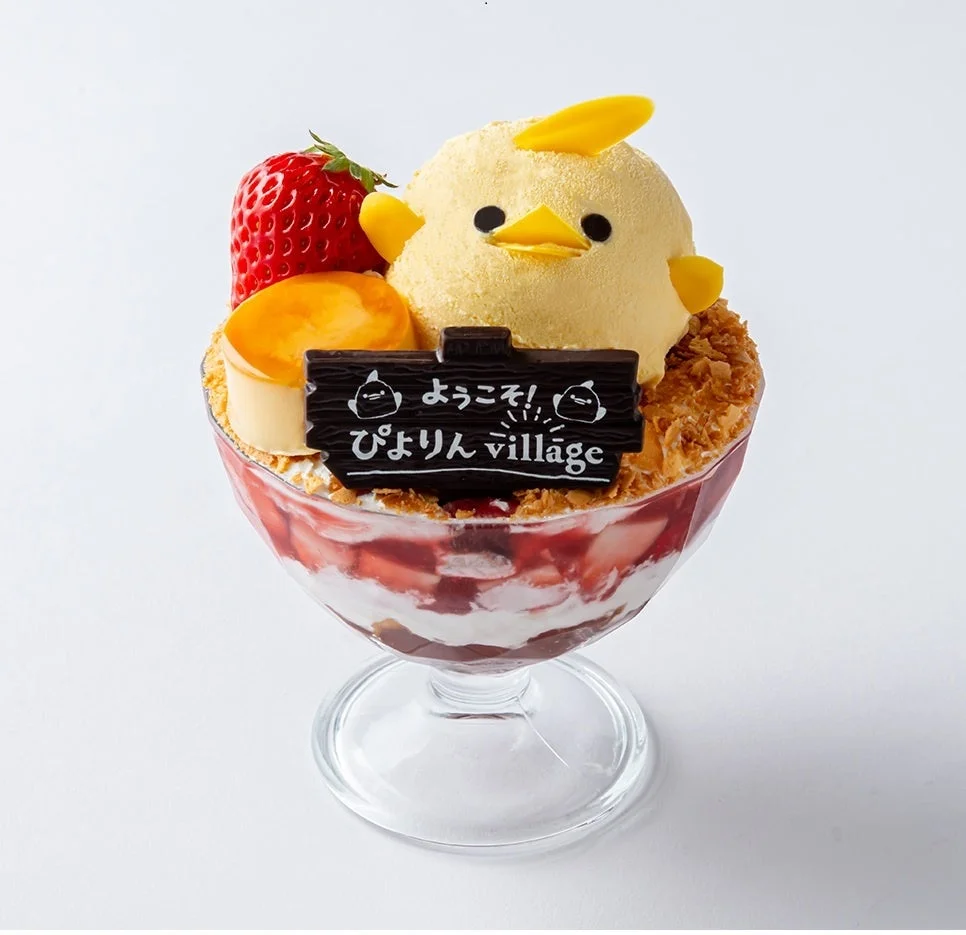ひよこをモチーフにしたかわいらしいパフェです。いちごやプリンが層になっており、「ようこそ！ぴよりん village」と書かれたチョコレートプレートが添えられています。