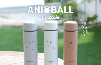 Three pastel AniBall by Zooie bottles with cute cat faces on a wooden table outdoors. The brand name appears above.