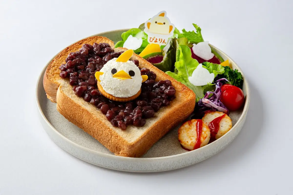 ぴよりんのひよこ型スイーツが乗ったあんトーストを主役に、新鮮な野菜のサラダとポテトなどのサイドメニューが添えられた、可愛らしくて彩り豊かなワンプレートの朝食またはブランチです。