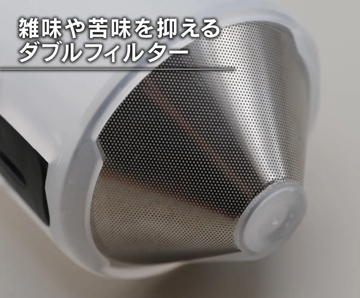 雑味や苦味を抑えるためのダブルフィルターのクローズアップ画像です。細かい穴が開いた金属メッシュで構成されており、コーヒーメーカーなどの調理器具の一部と推測されます。