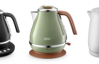 Three electric kettles side by side black with a digital base green with a brown handle and a white kettle with a water gauge on its base