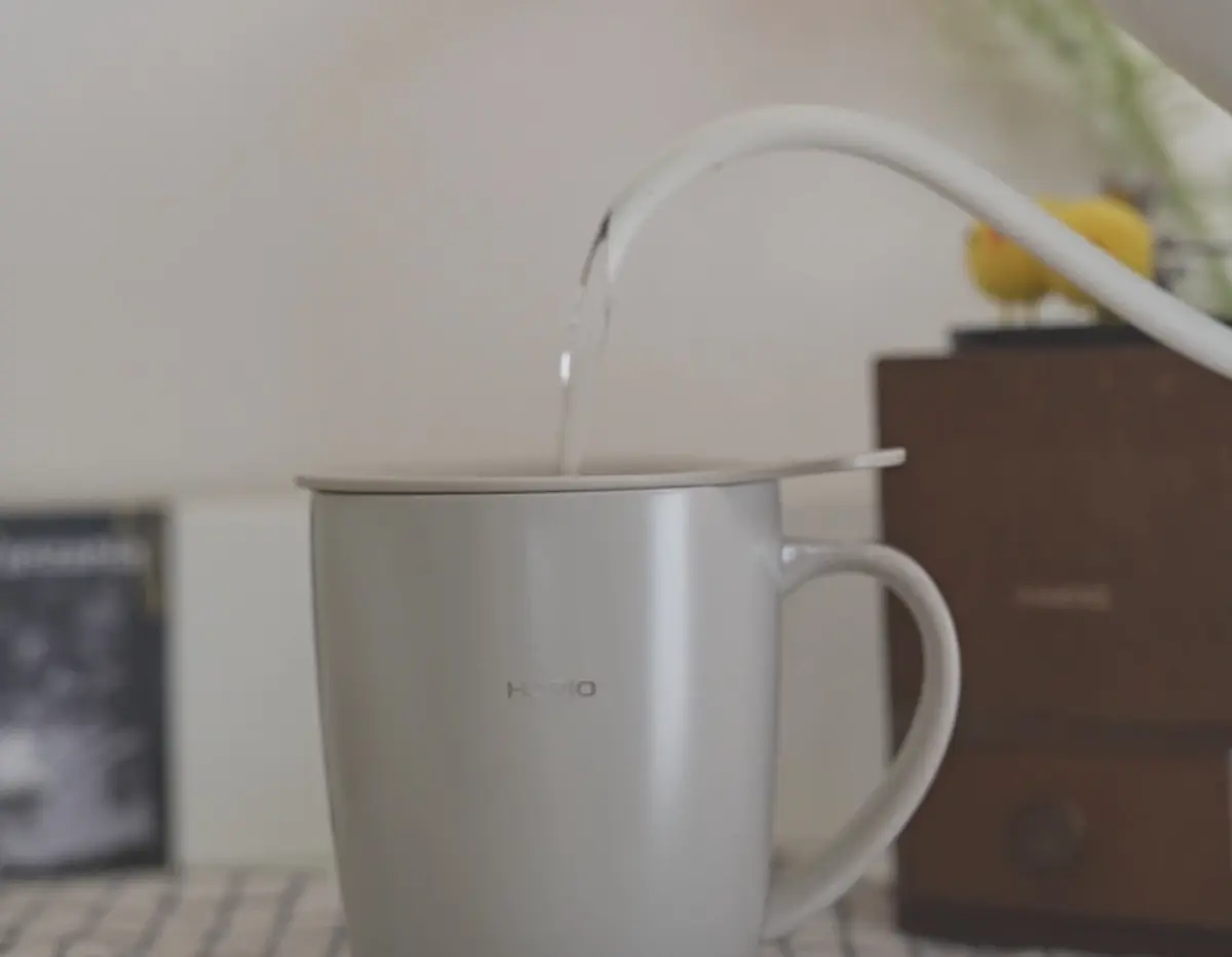 1780401608ujcDKYCFZJkAtzxShynQmLUp | コーヒーステーション Close up of a silver kettle with its lid raised as water pours into it from a curved faucet