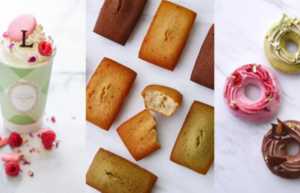 Triptych of treats: mint-green cup with whipped cream, berries and flower decorations; scattered financiers (pan-sized almond cakes) in the center; and frosted donuts in pink, brown, and olive on a marble surface (right).