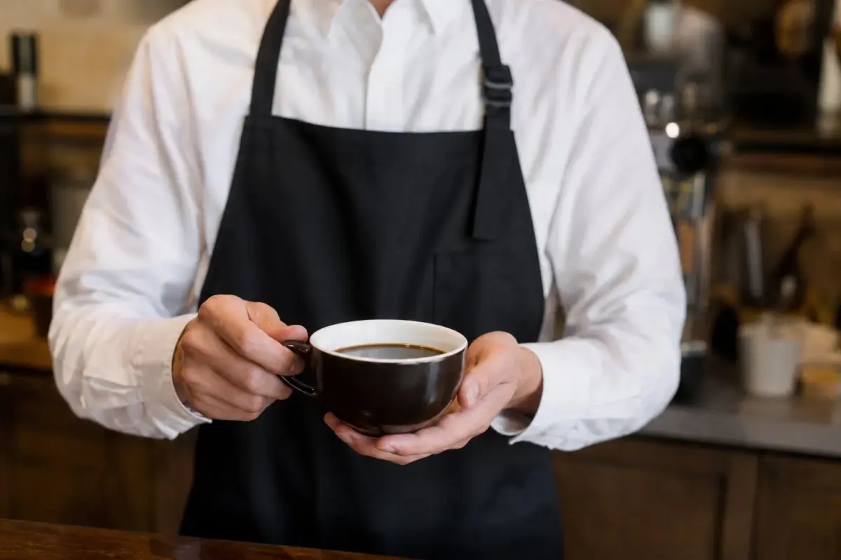 コーヒーカップを持つ人物